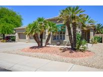 Charming single-story home boasts a low-maintenance landscape with palm trees and neutral exterior at 17710 W Buena Vista Dr, Surprise, AZ 85374