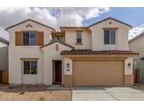Inviting two-story home showcasing desert landscaping, a two-car garage, and a charming facade with shuttered windows at 18383 W Monte Lindo Ln, Surprise, AZ 85387