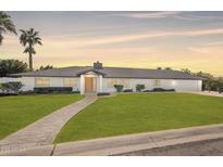 Stunning single story home with a well-manicured front yard and inviting brick walkway at 1911 E Claremont St, Phoenix, AZ 85016