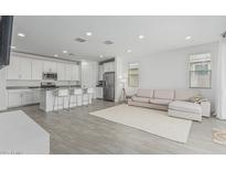 Open-concept living space featuring tile floors, a modern sofa, and a well-appointed kitchen at 23068 E Stacey Rd, Queen Creek, AZ 85142
