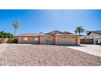 Charming single-story home with a two-car garage, desert landscaping, and mature palm trees at 2337 E Riviera Dr, Tempe, AZ 85282