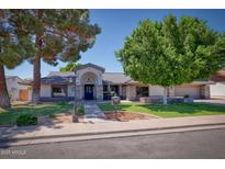 Charming single story home featuring a well-manicured lawn and mature trees in a suburban neighborhood at 2424 E Ivy St, Mesa, AZ 85213