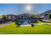 Elegant home featuring a lush lawn, meticulously arranged potted plants, and a paved walkway to a grand entrance at 3118 W Glenhaven Dr, Phoenix, AZ 85045