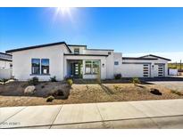 Stunning modern home featuring a sleek white exterior, desert landscaping, and a three car garage at 3335 W Desert Dawn Dr, Phoenix, AZ 85083