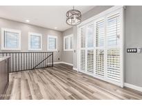 Bright living room boasts wood-look tile floors, neutral walls, shuttered windows and sliding doors to a balcony at 42424 N Gavilan Peak Pkwy # 24206, Anthem, AZ 85086