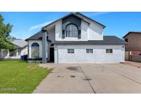 Two-story home featuring stucco siding, a dark roof, and an attached two-car driveway at 9026 W Cambridge Ave, Phoenix, AZ 85037