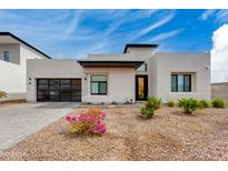 Modern home featuring a black framed glass garage door and desert landscaping at 100 W Northern Ave # 8, Phoenix, AZ 85021