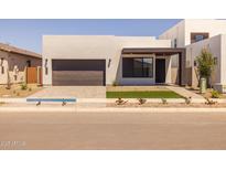 Modern home featuring a minimalist design, a dark brown garage door, and low maintenance landscaping at 10230 E Utah Ave, Mesa, AZ 85212
