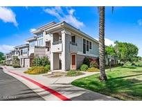 Charming multi-story home with a well-manicured lawn, beautiful landscaping, and a sunny sky at 15221 N Clubgate Dr # 2065, Scottsdale, AZ 85254