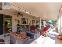 Inviting covered patio featuring comfortable seating, fire pit, and ceiling fan for outdoor relaxation at 15797 W Cinnabar Dr, Surprise, AZ 85374