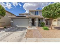 Charming two-story home featuring desert landscaping, solar panels, a two-car garage and a brick walkway at 15812 W Lisbon Ln, Surprise, AZ 85379