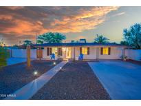 Inviting single-story home with a well-lit walkway and chairs adding to the curb appeal at 1644 W Roma Ave, Phoenix, AZ 85015