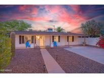 Charming single-story home featuring manicured front yard, walkway, and colorful sky at dusk at 1644 W Roma Ave, Phoenix, AZ 85013