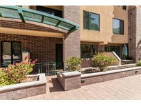 Charming brick building entrance with a covered seating area and manicured landscaping at 17 W Vernon Ave # 121, Phoenix, AZ 85003