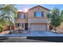 Two-story home featuring a neat front yard, neutral colors, and an attached two-car garage at 18586 N Lariat Rd, Maricopa, AZ 85138