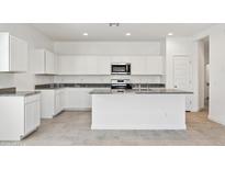 Modern kitchen featuring white cabinets, granite countertops, and stainless steel appliances at 22540 N Lynn St, Maricopa, AZ 85138