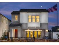 Charming two-story home with gray stucco, white trim and an American flag in the early evening light at 2480 W Rowel Rd, Phoenix, AZ 85085