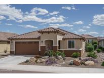 Charming single-story home featuring a tiled roof, well-manicured landscaping, and an attached two-car garage at 26017 W Maple Dr, Buckeye, AZ 85396