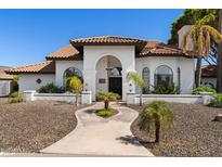 Charming home featuring a Spanish tile roof, arched entryway, and well-manicured desert landscaping at 3209 E Fox St, Mesa, AZ 85213