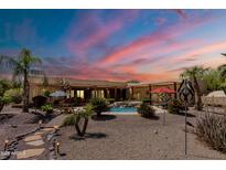 Inviting backyard featuring a pool with waterfall feature, desert landscaping, and patio furniture at 37809 N 9Th Pl, Phoenix, AZ 85086