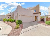 Stylish beige stucco home featuring a two-car garage, desert landscaping, and well-maintained walkway at 544 N Alma School Rd # 28, Mesa, AZ 85201