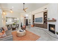 Open-concept living room with modern fireplace, built-ins, and easy access to the kitchen and dining area at 6579 E Shooting Star Way, Scottsdale, AZ 85266