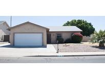 Charming single-story home with a well-maintained front yard and two car garage at 749 N 99Th St, Mesa, AZ 85207