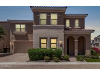 Charming two-story home with a neutral color palette, arched entry, and well-manicured landscaping at 9733 E Axle Ave, Mesa, AZ 85212