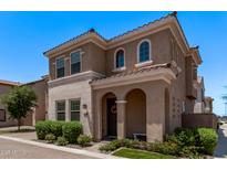 Charming two-story home features a tile roof, arched entryway, manicured landscaping, and beautiful stone accents at 9733 E Axle Ave, Mesa, AZ 85212