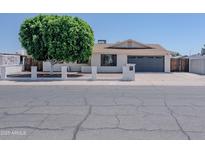 Charming single-story home featuring a white brick facade, well-manicured lawn, and an attached two-car garage at 10609 N 32Nd Cir, Phoenix, AZ 85029