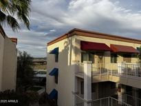 Condo's exterior showcasing its charming facade with awnings and a scenic view from the balcony at 12123 W Bell Rd # 337, Surprise, AZ 85378