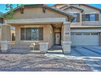 View of the front of the home showcasing the cozy covered porch and a view of the two-car garage at 16112 W Durango St, Goodyear, AZ 85338