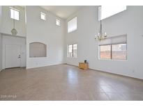 Bright living room featuring soaring ceilings, clerestory windows, and tile flooring at 16112 W Durango St, Goodyear, AZ 85338
