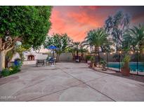 Backyard with desert landscaping, outdoor fireplace and dining area at 16153 W Lisbon Ln, Surprise, AZ 85379