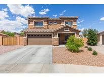 Charming two-story home featuring a two-car garage and a well-maintained, low-maintenance desert-landscaped front yard at 21972 W Pima St, Buckeye, AZ 85326