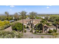 Stunning estate with lush landscaping, fountain, and palm trees welcomes you home at 5615 N Invergordon Rd, Paradise Valley, AZ 85253