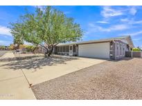 Charming single-story home featuring mature tree, covered patio, and a two-car garage at 6749 E Ellis St, Mesa, AZ 85205