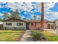 Charming single-story home with a well-maintained lawn and inviting desert landscaping at 6907 E Portland St, Scottsdale, AZ 85257