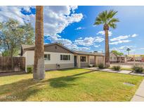 Attractive single-Gathering home featuring a lush lawn and mature desert landscaping at 6907 E Portland St, Scottsdale, AZ 85257