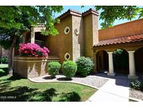 Charming condo exterior features a landscaped yard and stucco facade with blossoming bougainvillea at 6945 E Cochise E Rd # 117, Paradise Valley, AZ 85253