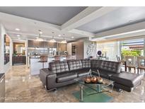 Open-concept living room featuring a large sectional sofa, modern kitchen and marble flooring at 7131 E Rancho Vista Dr # 7011, Scottsdale, AZ 85251