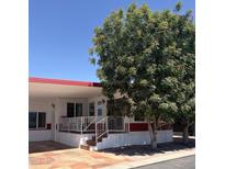 Charming single-story home with a covered front porch, mature trees, and red and white accents at 7750 E Broadway Rd # 604, Mesa, AZ 85208