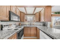 Traditional kitchen with granite counters, wood cabinets, and modern appliances at 786 Cinnabar Dr, Apache Junction, AZ 85119