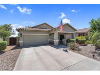 Charming single-story home featuring a two-car garage, desert landscaping, and an American flag at 1081 W Stephanie Ln, San Tan Valley, AZ 85143