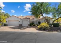 Inviting home featuring a tile roof, mature landscaping, and a convenient two-car garage at 11143 E Onyx Ct, Scottsdale, AZ 85259