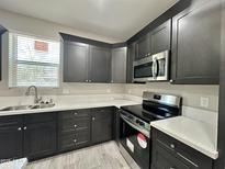 This kitchen is equipped with modern appliances, sleek cabinetry, and pristine white countertops at 11216 W Apache St, Avondale, AZ 85323
