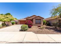 Charming single-story home with a well-manicured front yard and a two-car garage at 12838 W Desert Mirage Dr, Peoria, AZ 85383