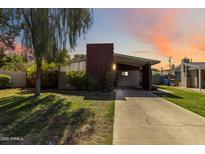 Charming single-story home featuring a unique chimney design and covered parking, beautifully landscaped with lush greenery at 1329 E Catalina Dr, Phoenix, AZ 85014