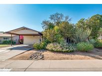 Charming single-story home featuring mature landscaping and a welcoming covered carport at 15212 N 37Th Ave, Phoenix, AZ 85053