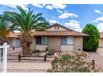 Charming single-story brick home with desert landscaping, palm trees, and a sunny sky at 1643 W Naranja Ave, Mesa, AZ 85202